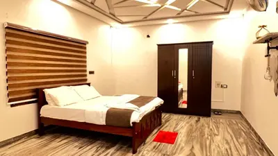 a bedroom with a bed with a wooden headboard at Royal Rivera Holiday Home in Kalpetta