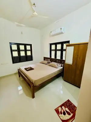 a bedroom with a bed and a mirror in it at Ocean pearl homestay-pariyaapuram