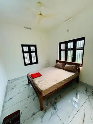 a bedroom with a bed in the middle of a room at Ocean pearl homestay-pariyaapuram