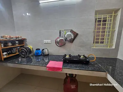 a kitchen counter with a black counter top at SHI's Krishna 2BHK Villa Furnished Cozy Stay in Coimbatore