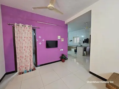 a living room with a purple wall and a tv at SHI's Krishna 2BHK Villa Furnished Cozy Stay in Coimbatore