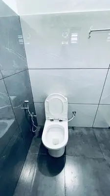 a bathroom with a white toilet in a stall at The Karlyle Homestay in Sultan Bathery