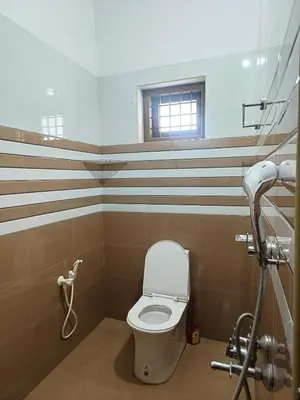 a bathroom with a toilet and a window at Riverfront Villa in Kochi in Kodungallūr