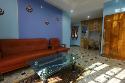 a living room with a couch and a glass table at Cozy Ooty Resort in Ooty