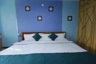 a blue bedroom with a large bed with blue walls at Cozy Ooty Resort in Ooty