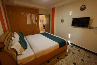 a bedroom with a bed and a flat screen tv at Cozy Ooty Resort in Ooty