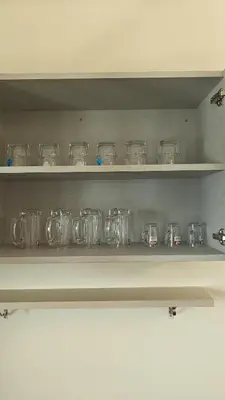 a shelf with many glass jars on it at Gamani in Mysore