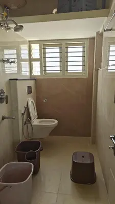 a bathroom with a toilet and a sink at Gamani in Mysore