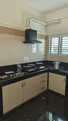 a kitchen with a stove and a counter top at Gamani in Mysore