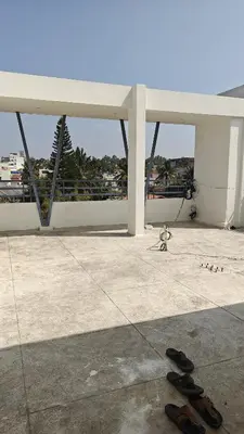 a group of shoes on the ground in front of a building at Gamani in Mysore