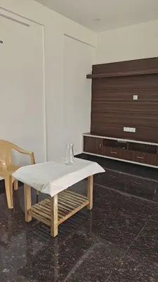 a table and a chair in a room at Gamani in Mysore