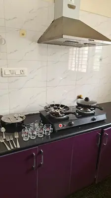 a kitchen with a stove top oven in a kitchen at Gamani in Mysore