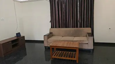 a living room with a couch and a table at Gamani in Mysore