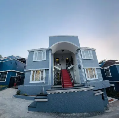 a blue house with a staircase in front of it at Little Home By D2V in Ooty