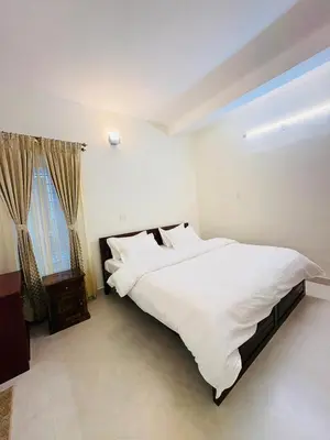 a bedroom with a large white bed and a window at Little Home By D2V in Ooty