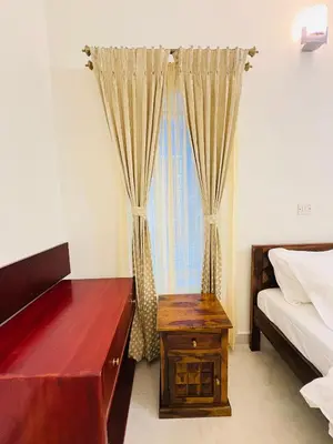 a bedroom with a bed and a desk and a window at Little Home By D2V in Ooty