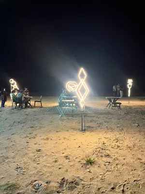 a light up sign on the beach at night at Ichakkans beach resort in Irimbranallūr