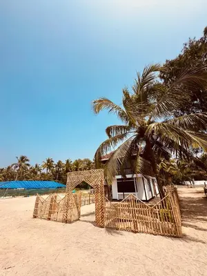 a building on a beach with a palm tree at Ichakkans beach resort in Irimbranallūr