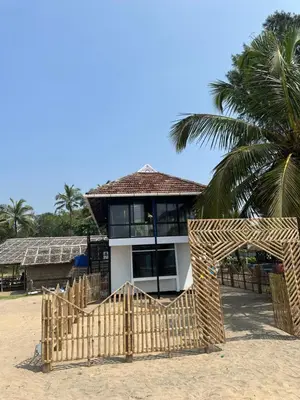 a house on the beach with a wooden gate at Ichakkans beach resort in Irimbranallūr