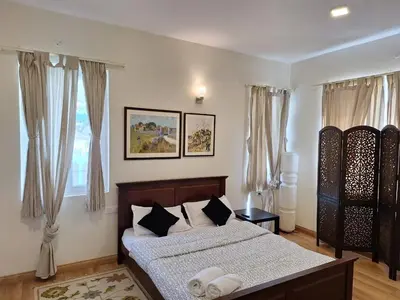 a bedroom with a bed and a window with curtains at Neom Valley in Ketti