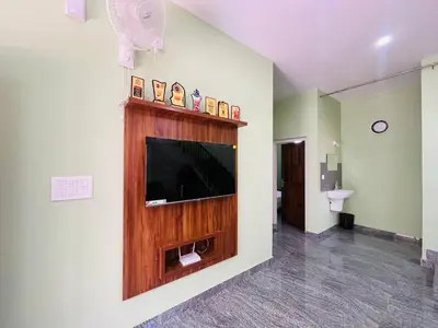 a living room with a flat screen tv on a wall at AGNEYA Holiday Home in Wayanad