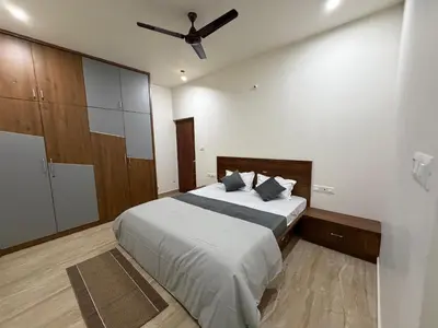 a bedroom with a bed with a ceiling fan at The Residence 267 Home Stay in Mysore