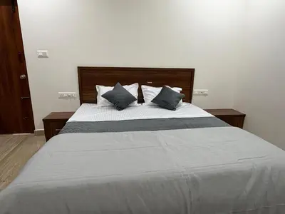 a bedroom with a large bed with blue pillows at The Residence 267 Home Stay in Mysore