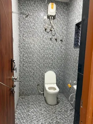 a bathroom with a toilet in a small room at The Residence 267 Home Stay in Mysore