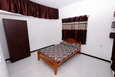 a small bedroom with a bed and a window at Hillside haven ooty in Ooty
