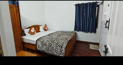 a small bedroom with a bed with a leopard print blanket at Hilarious Garden Ooty in Ooty