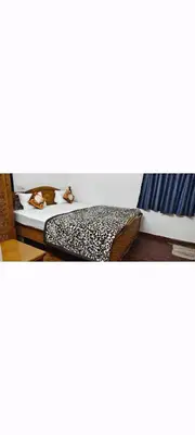 a bedroom with a bed with a leopard print at Hilarious Garden Ooty in Ooty
