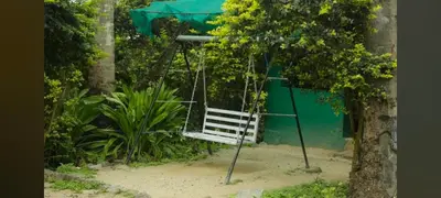 a swing in a garden with a tree at Hilarious Garden Ooty in Ooty
