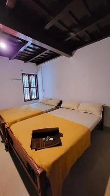 a room with two beds with a purse on it at Wildora Junglevilla Wayanad in Chekadi