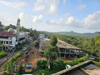 a city with a clock tower and a street at Hamai Grand Dormitory in Ambalavayal