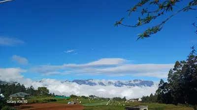 a view of a mountain with clouds in the sky at Mud bees resort in Kanthalloor