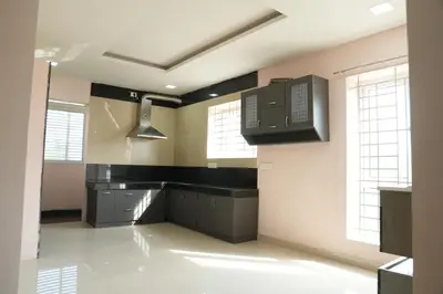 a large kitchen with black counter tops and windows at Luxury Stays in Coimbatore