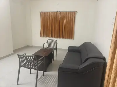 a living room with a couch and chairs and a table at Nexusliving in Coimbatore