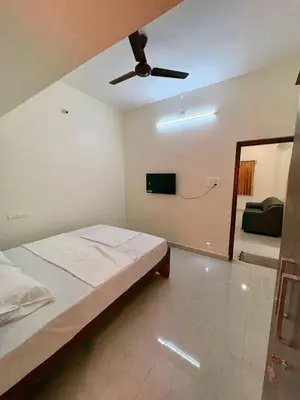a bedroom with a bed and a ceiling fan at Nexusliving in Coimbatore