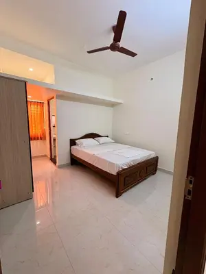 a bedroom with a bed and a ceiling fan at Nexusliving in Coimbatore