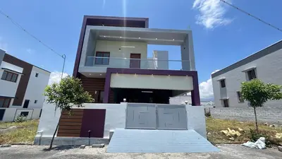 a large house with a garage in front of it at House of KRM - Nilgiris Outlook in Kāramadai
