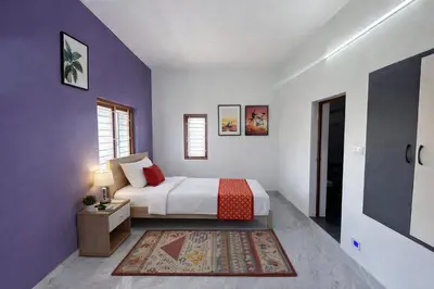 a bedroom with a king sized bed and purple walls at House of KRM - Nilgiris Outlook in Kāramadai
