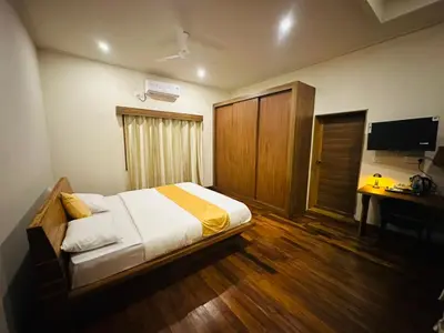a bedroom with a bed and a desk and a television at Sky16cafe in Kushālnagar