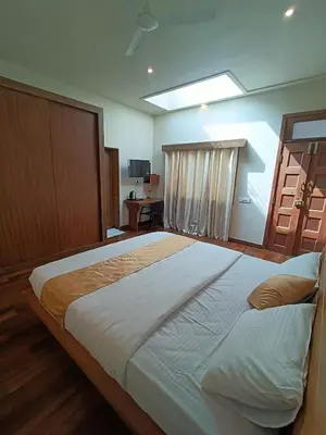 a bedroom with a large bed and a window at Sky16cafe in Kushālnagar