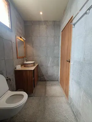 a bathroom with a toilet and a sink and a shower at Sky16cafe in Kushālnagar