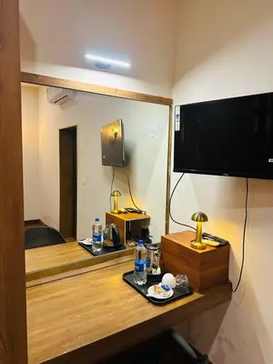 a room with a television and a table with a plate of food at Sky16cafe in Kushālnagar