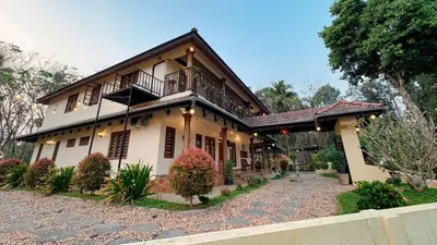 a house with a balcony on top of it at Pochans Zen in Thattakād