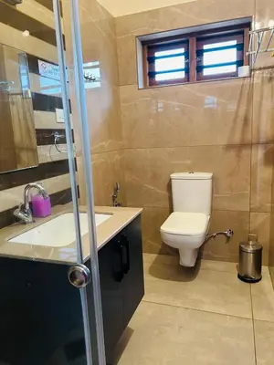 a bathroom with a toilet and a sink at Pochans Zen in Thattakād