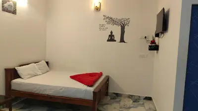 a small room with a bed with a red pillow on it at Nakshatra Home Stay in Vattavada