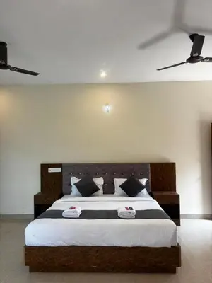 a bedroom with a large bed with two pillows at Surabhi Comforts Inn in Mysore