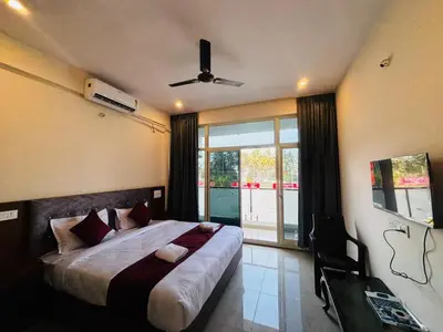 a bedroom with a large bed with a ceiling fan at Surabhi Comforts Inn in Mysore